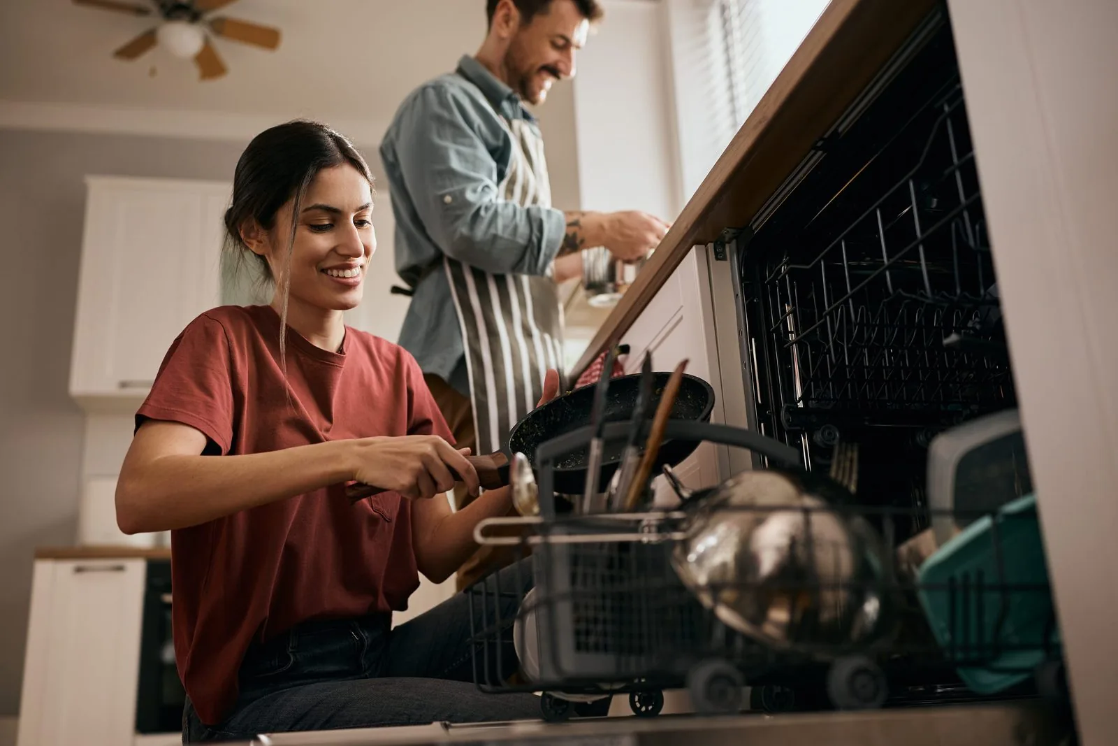 Couple in their kitchen while the dishwasher runs