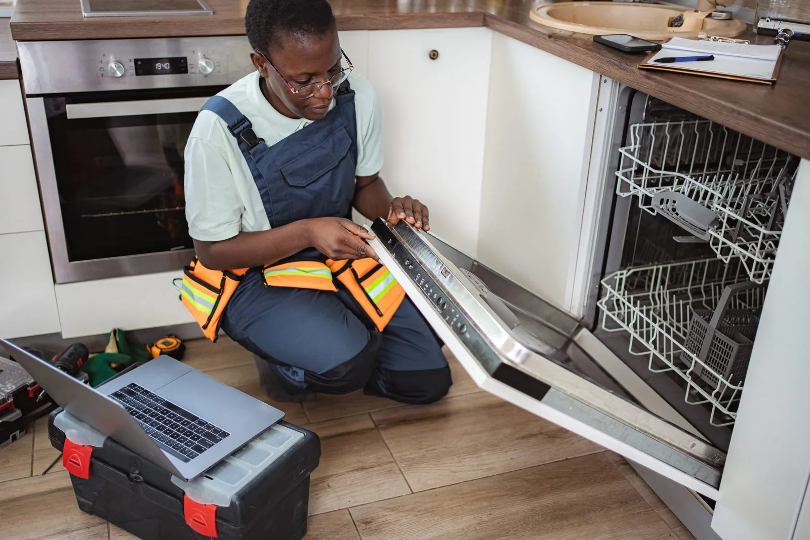 TrustTech technician running laptop diagnostics on a refrigerator