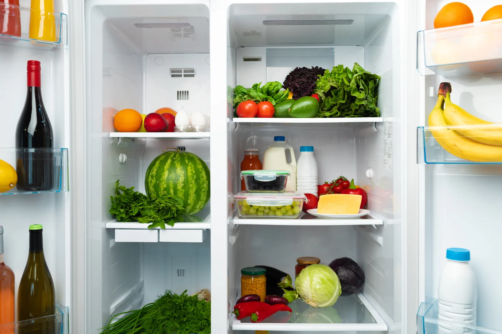 Open, well-stocked fridge held at a safe temperature