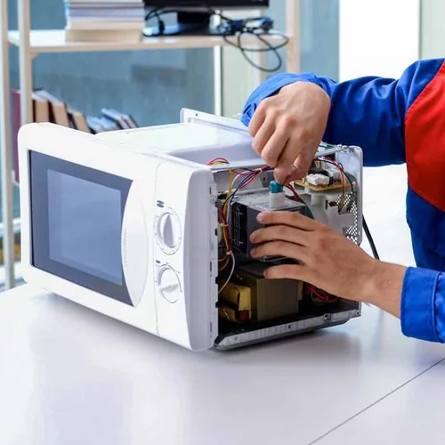 Technician repairing the interior of a microwave oven